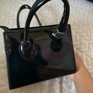 small black accent bag. comes with shoulder strap and it’s spacious for its size